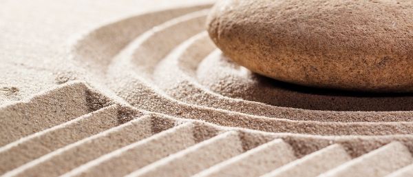 A single smooth stone on raked sand